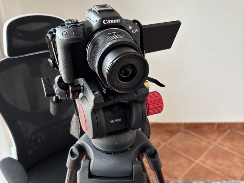 Canon EOS R50 mounted on a video tripod with a fluid head